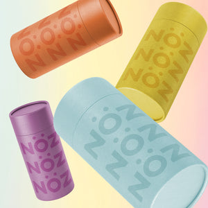 Product display of Nöz sunscreen collection in bright packaging in purple, yellow, orange, and blue