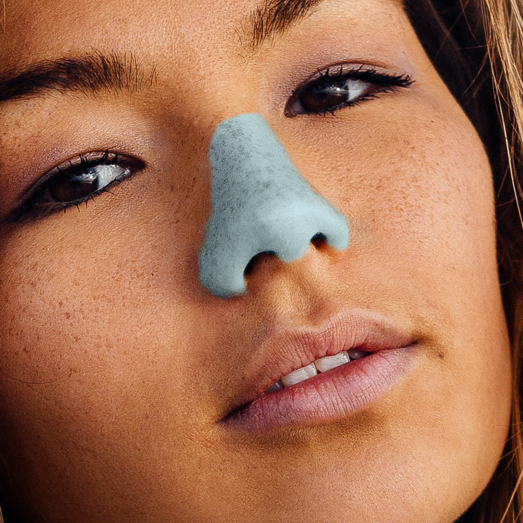 Close up of woman wearing blue Nöz sunscreen in blue 